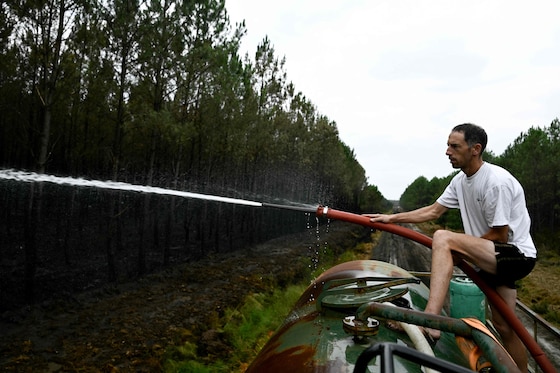 Un agriculteur arrosant les foyers d'incendie pour aider les pompiers à lutter contre le feu de forêt à Saint-Jean-d'Illac, à l'ouest de Bordeaux, le 27 juillet 2026.