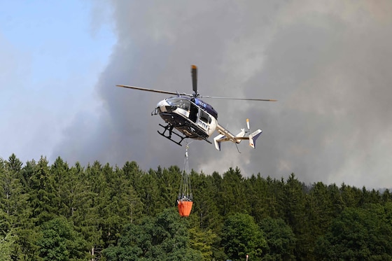 Un hélicoptère bombardier d'eau est engagé contre l'incendie.