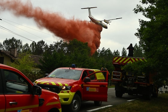Un avion Dash 8 Q400 MR de la Sécurité civile française largue du produit "retardant" au-dessus des arbres lors d’un incendie de forêt près de Luglon, dans le sud-ouest de la France.
