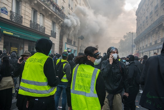 Des Gilets jaunes rassemblés dans une rue envahie par les gaz lacrymogènes lors de la manifestation à Paris, le 17 octobre 2026.
